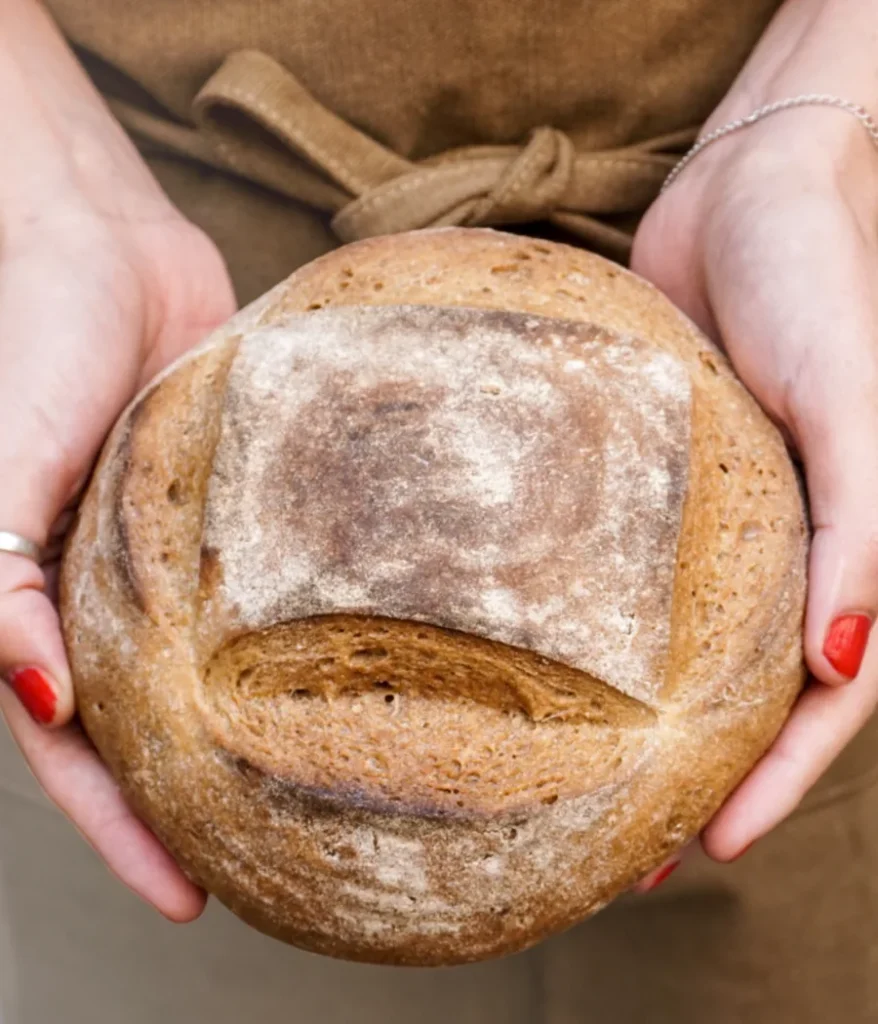  Pan casero sin gluten sostenido con las manos
